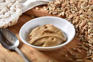 A small dish of fresh sunflower seed butter with rice cakes